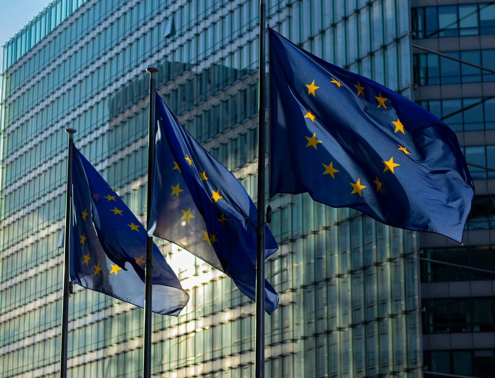 EU flags waving in front of the European Commission building in Brussels, Belgium.