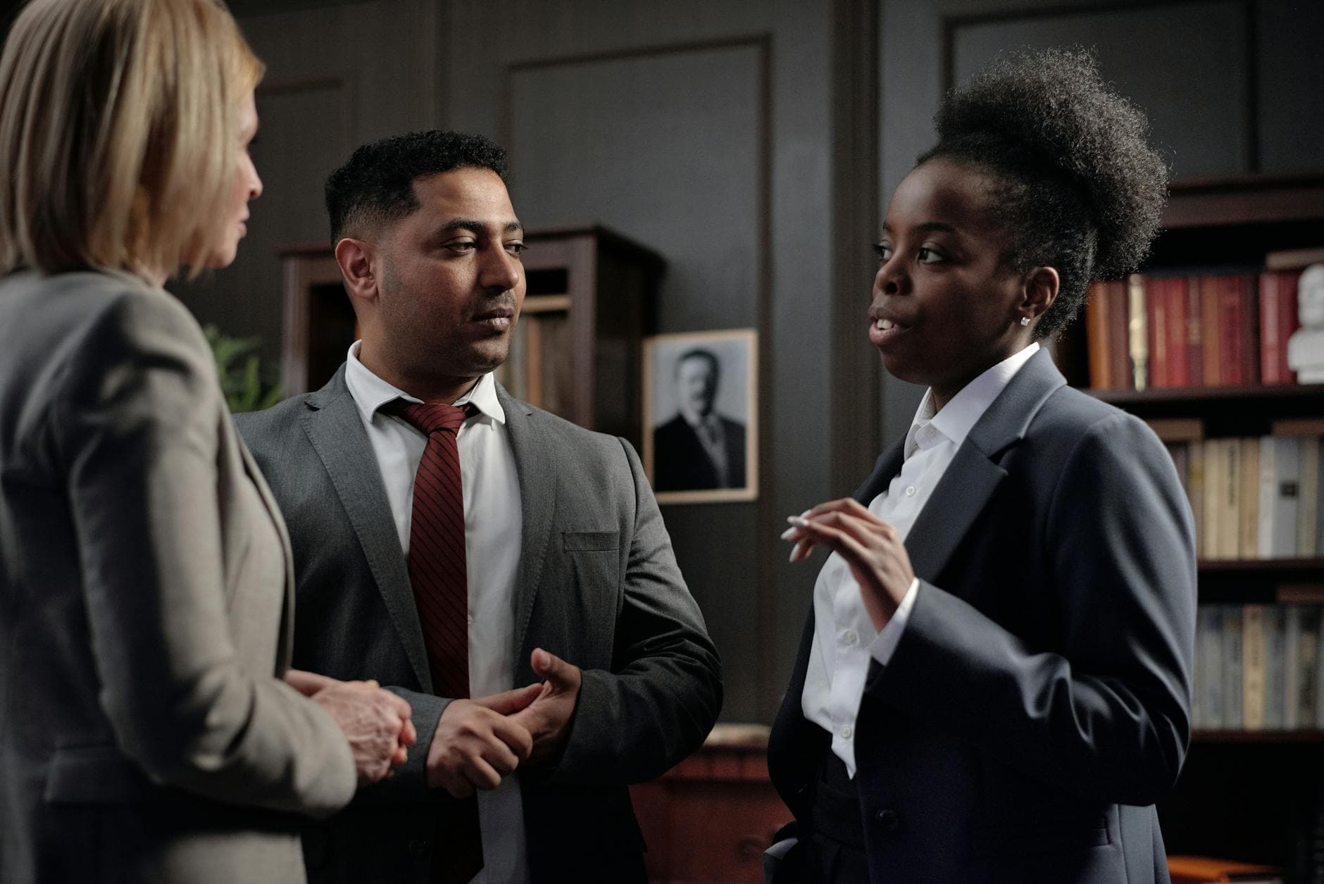 Group of diverse professionals discussing in office setting, highlighting teamwork and collaboration.