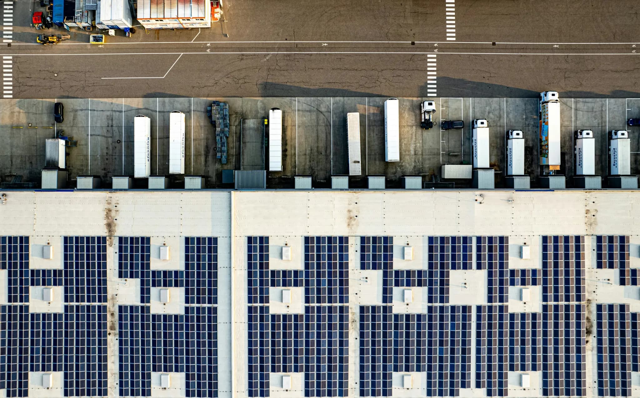 An aerial view of a parking lot with lots of solar panels
