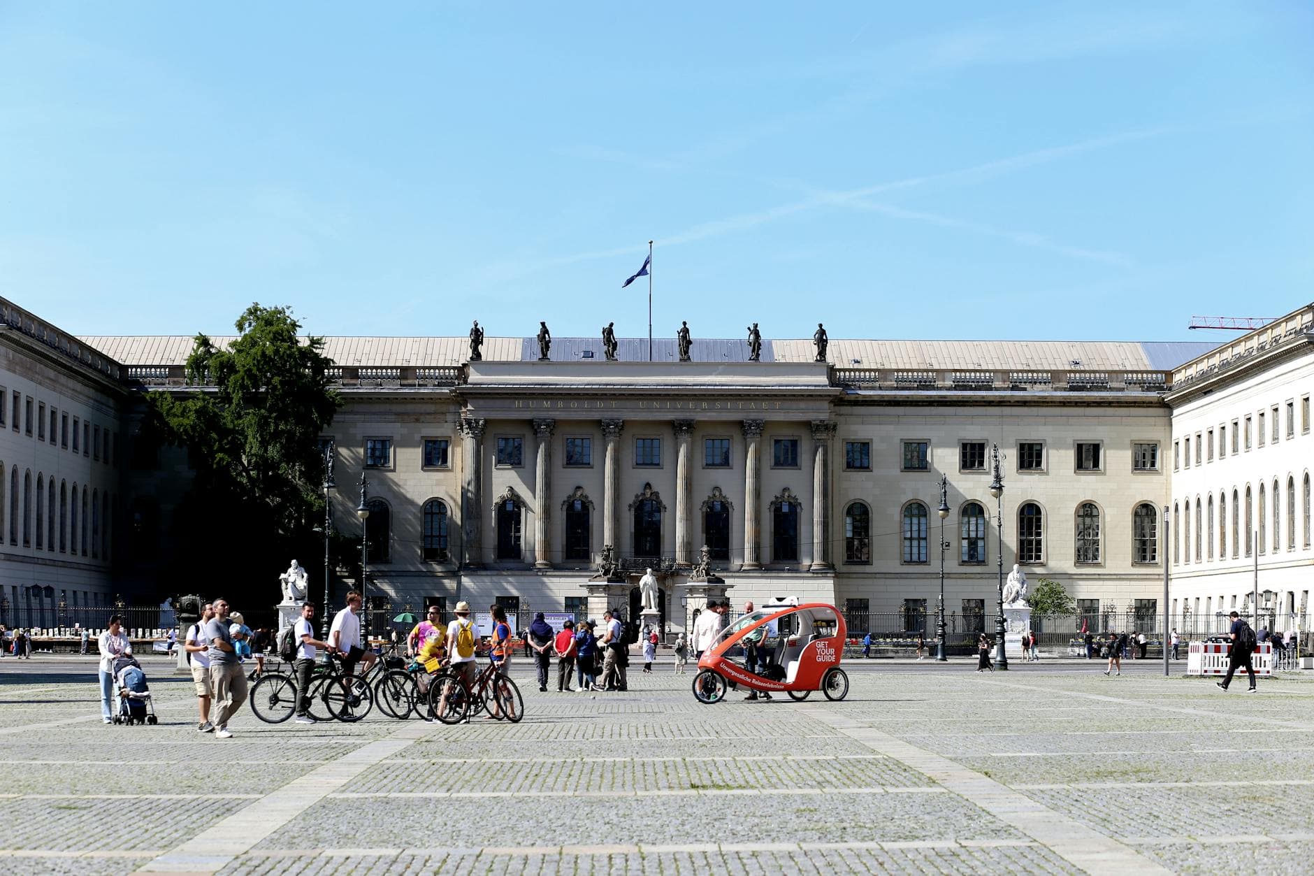 Vibrant day at Humboldt University plaza with people and bicycles.