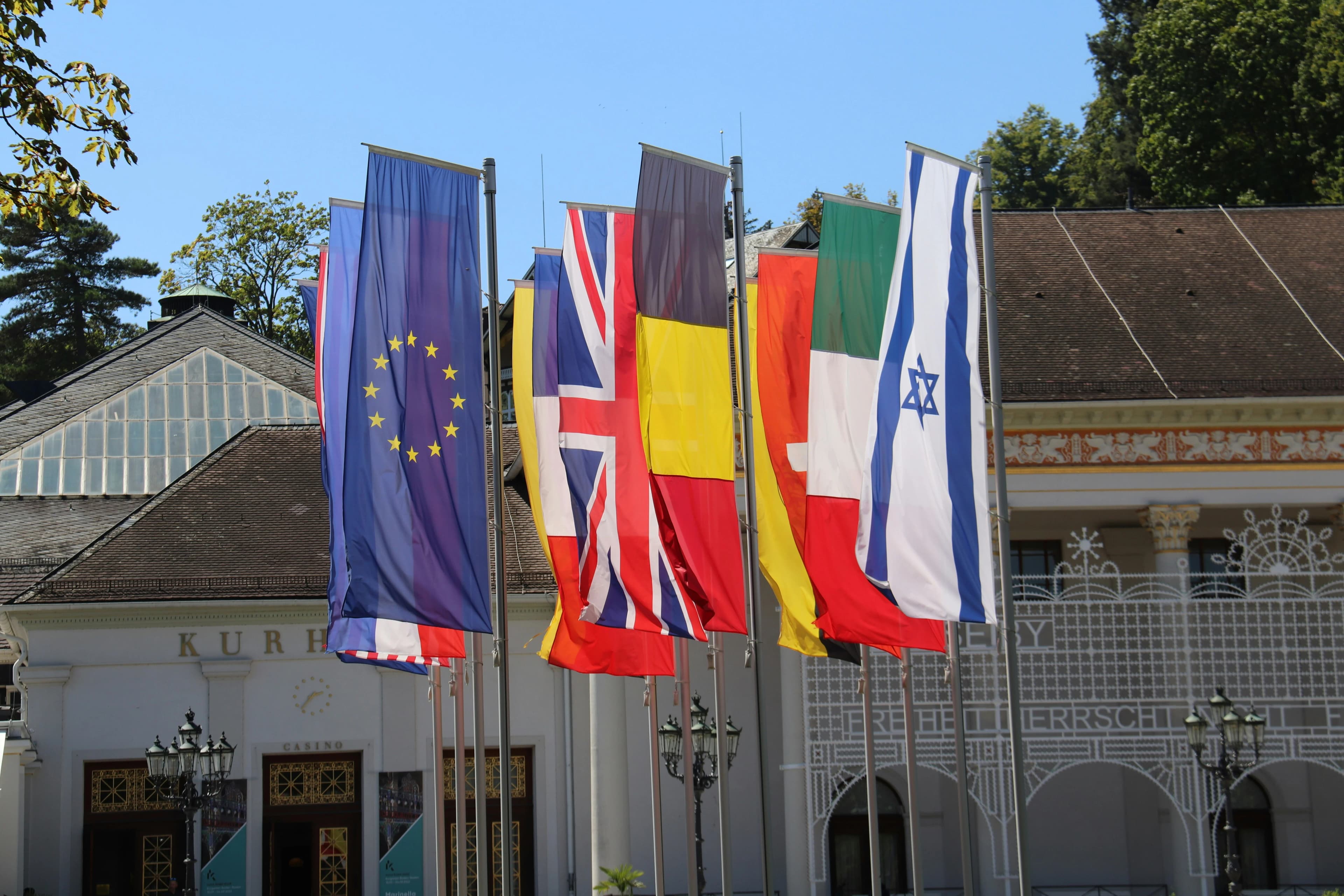 a row of flags in front of a building