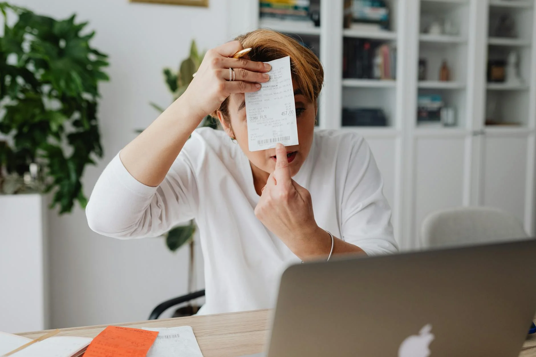 Businesswoman showing a receipt during a home office work session, highlighting technology integration.