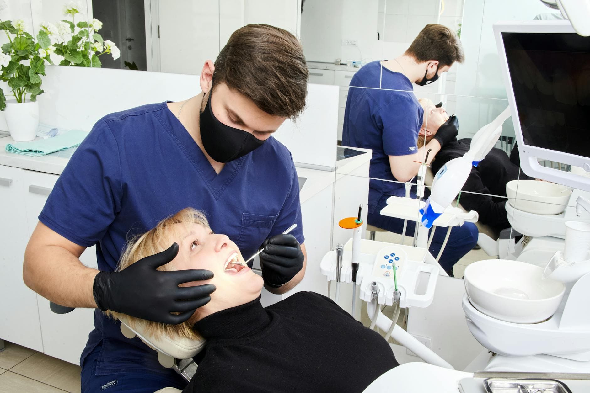 Dentist in scrubs checking a patient's teeth at a clinic in Belgrade, Serbia.