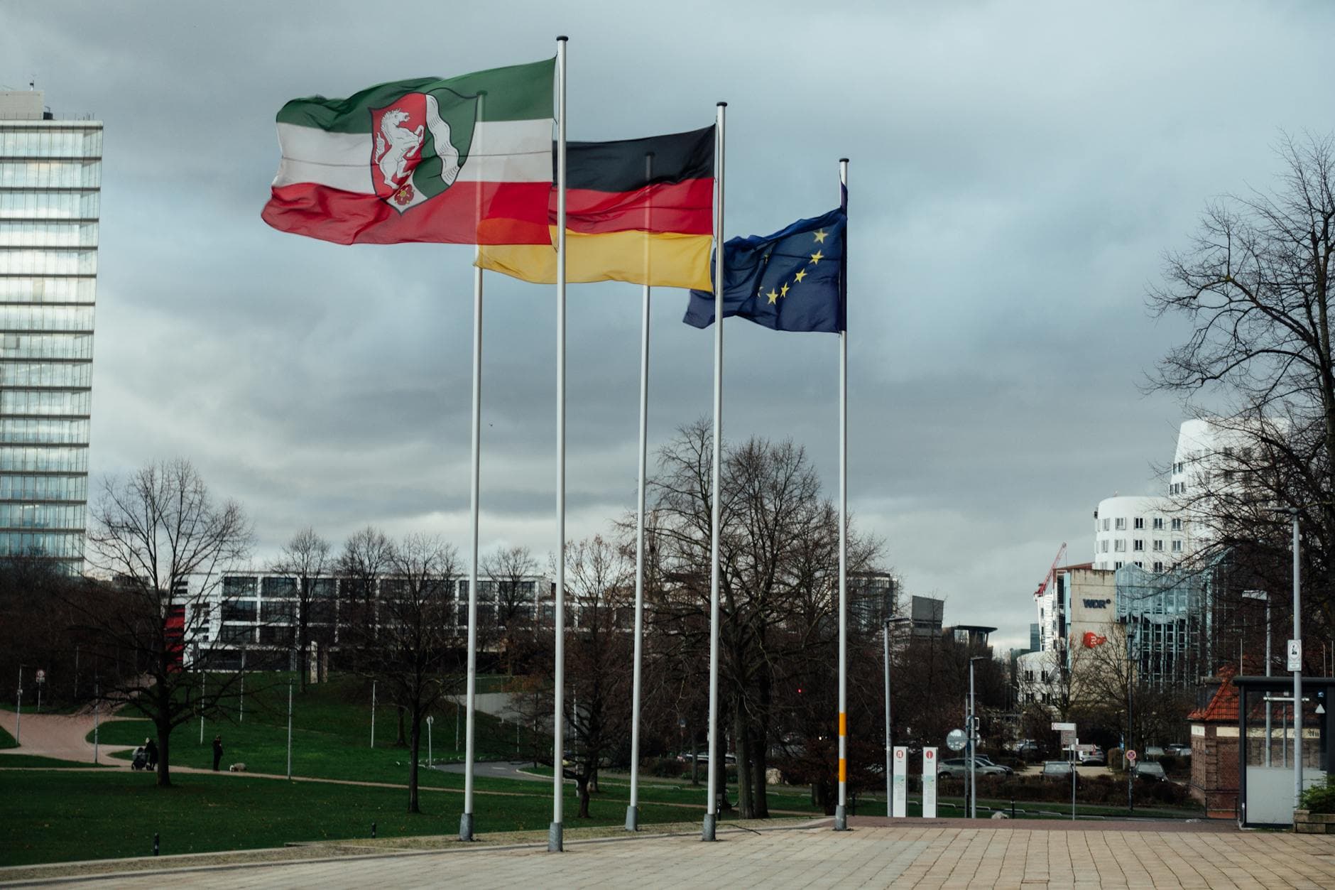 European and national flags in a Düsseldorf public space, showcasing modern architecture.