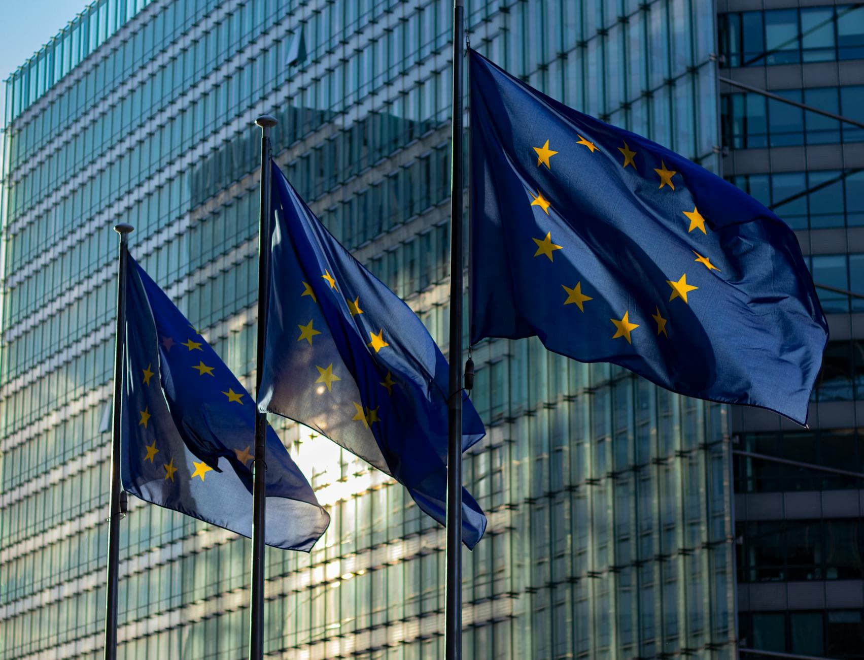 EU flags waving in front of the European Commission building in Brussels, Belgium.