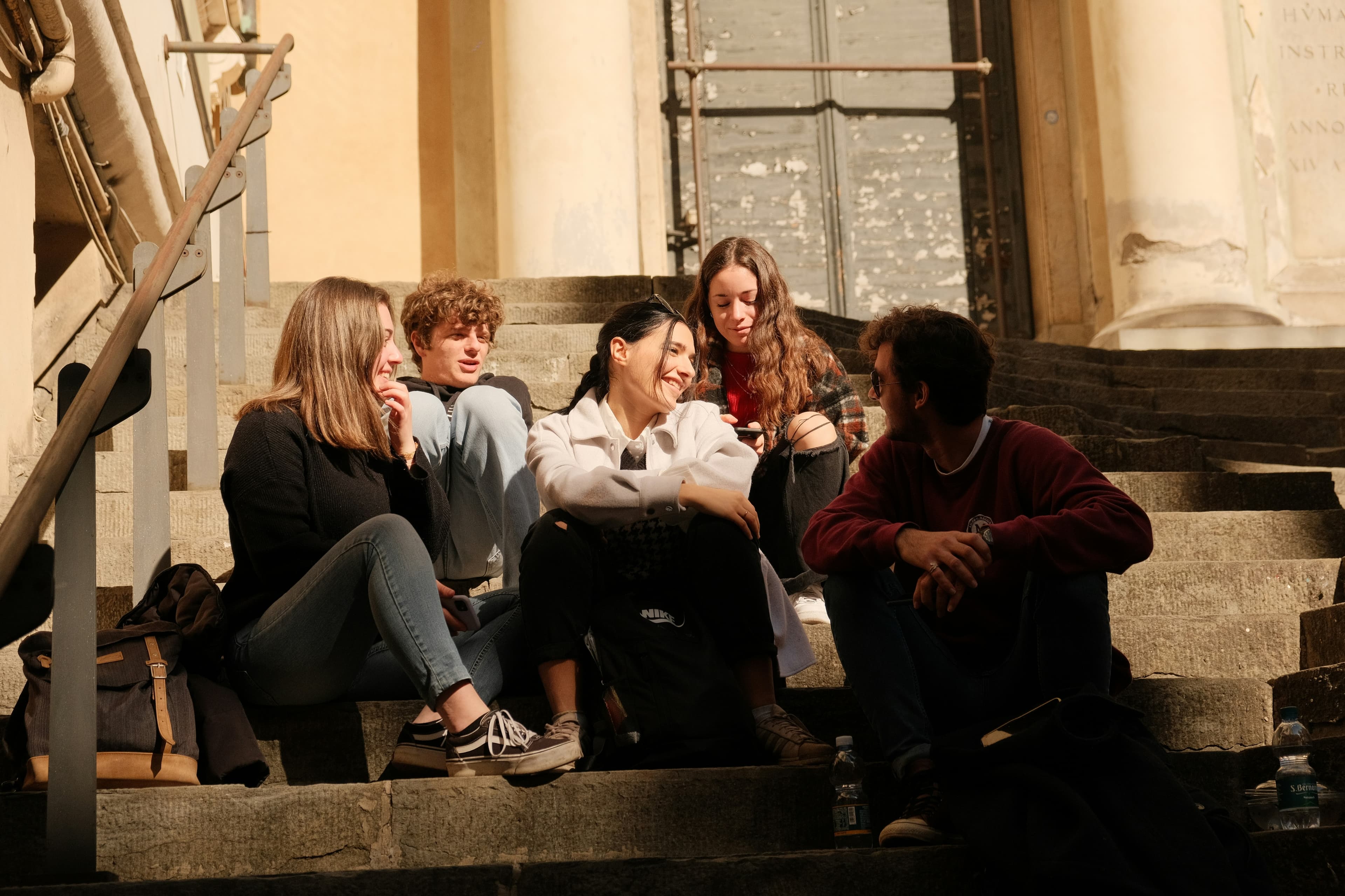 a group of people sitting on the steps of a building