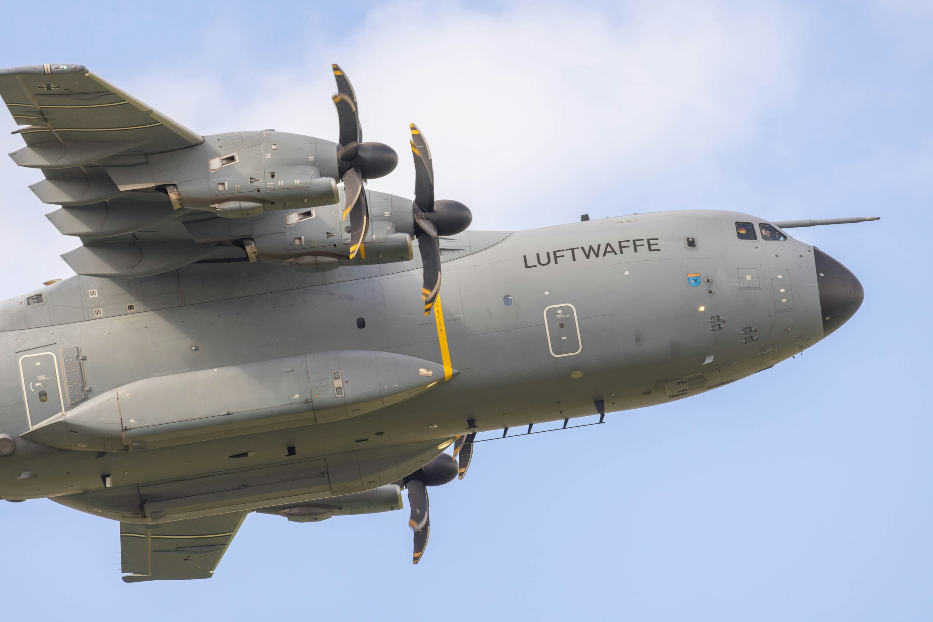 A large air plane flying through a blue sky